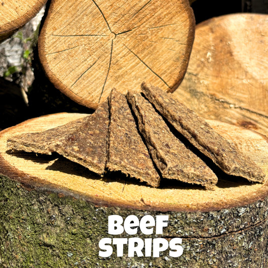 Natural dog treat – air-dried beef strips presented on wooden logs