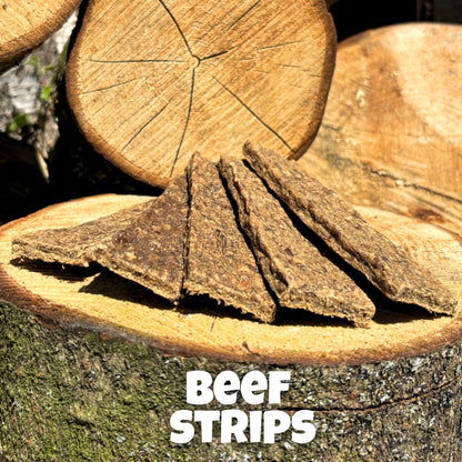 Natural dog treat – air-dried beef strips presented on wooden logs