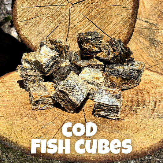 Natural dog treats – bite-sized cod fish cubes made from 100% cod skin, air-dried for flavour and nutrition, displayed on rustic wooden logs, ideal for training and skin health.