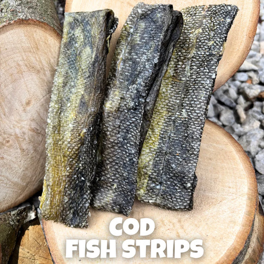 Natural dog treats – premium 100% cod fish strips, air-dried and displayed on rustic wooden logs, perfect for chewing enrichment and skin & coat health.