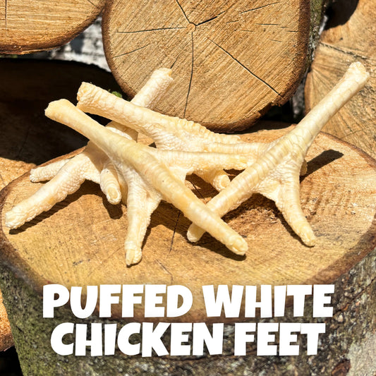 Natural dog treats – gently puffed, air-dried chicken feet on rustic wooden boards. Light, crunchy chews rich in glucosamine for healthy joints and teeth.